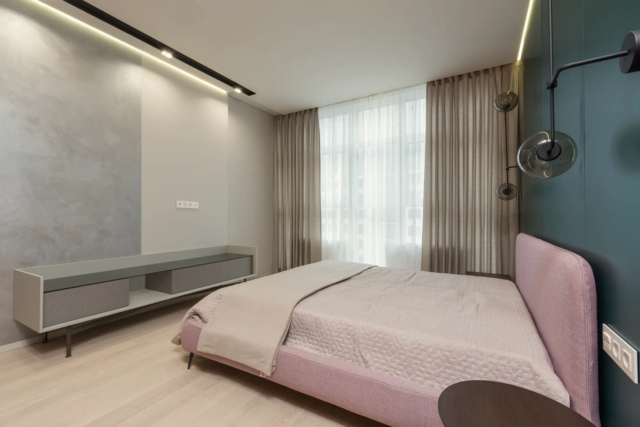 Second bedroom with a pink headboard, a low gray console and track lighting